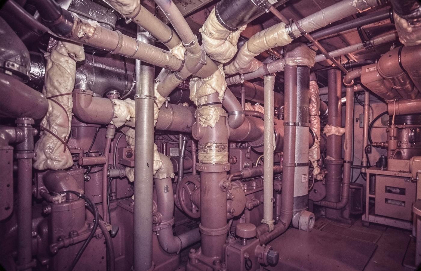 Ship engine room with asbestos-insulated pipes